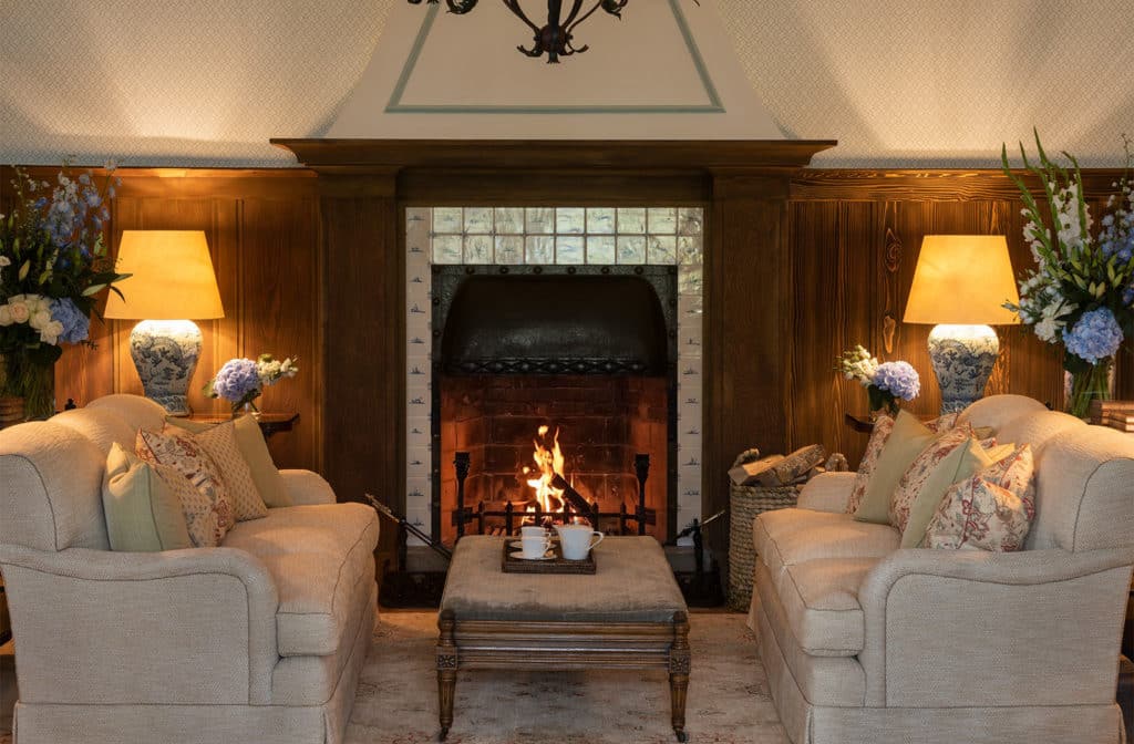a fireplace with two chairs and a coffee table