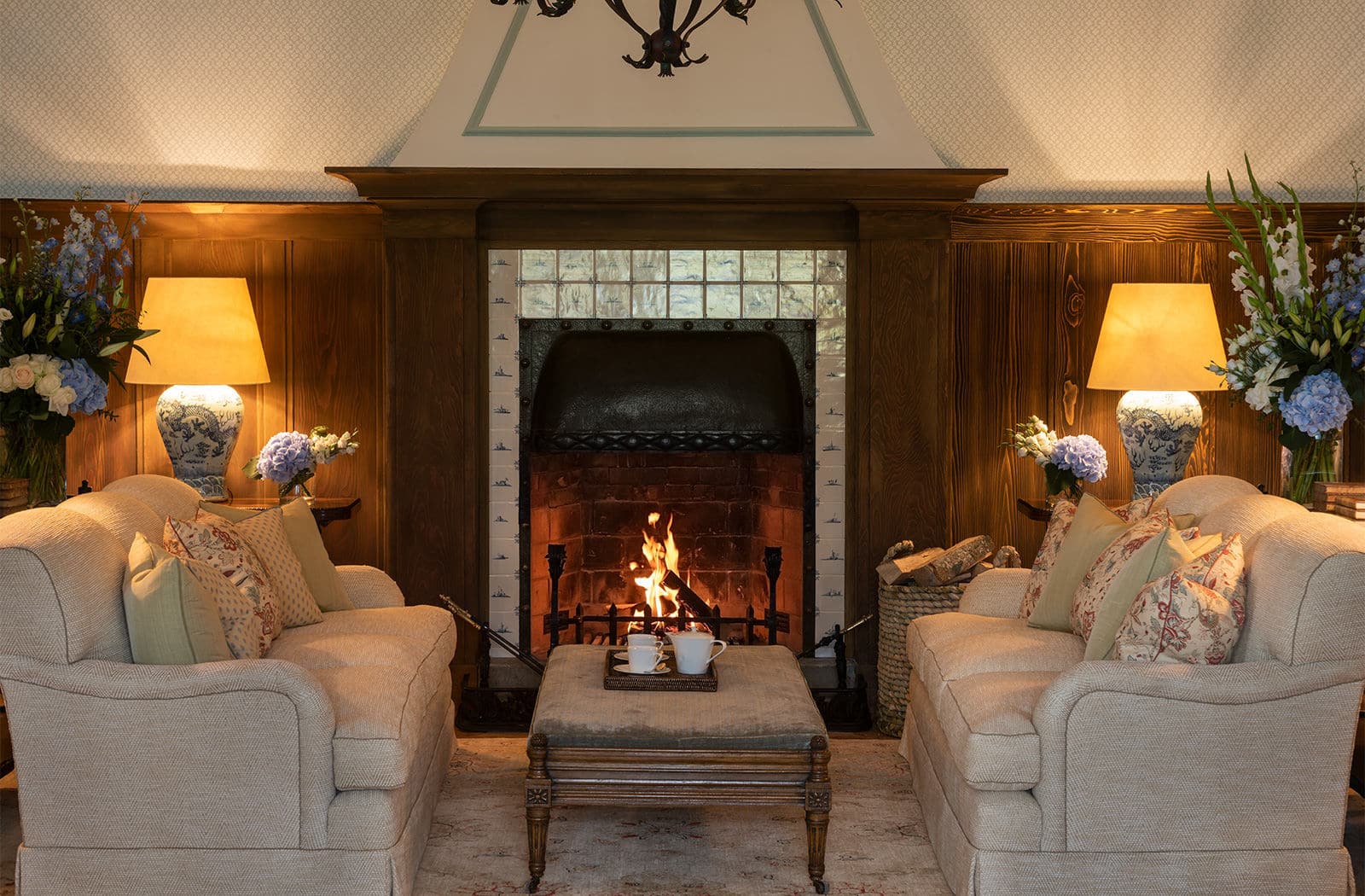 a fireplace with two chairs and a coffee table